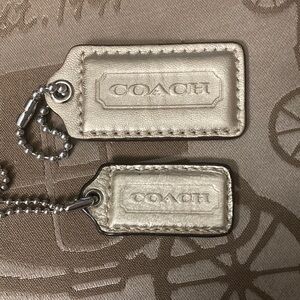 Coach gold metallic leather hangtags. One large, one small. With silver chain.